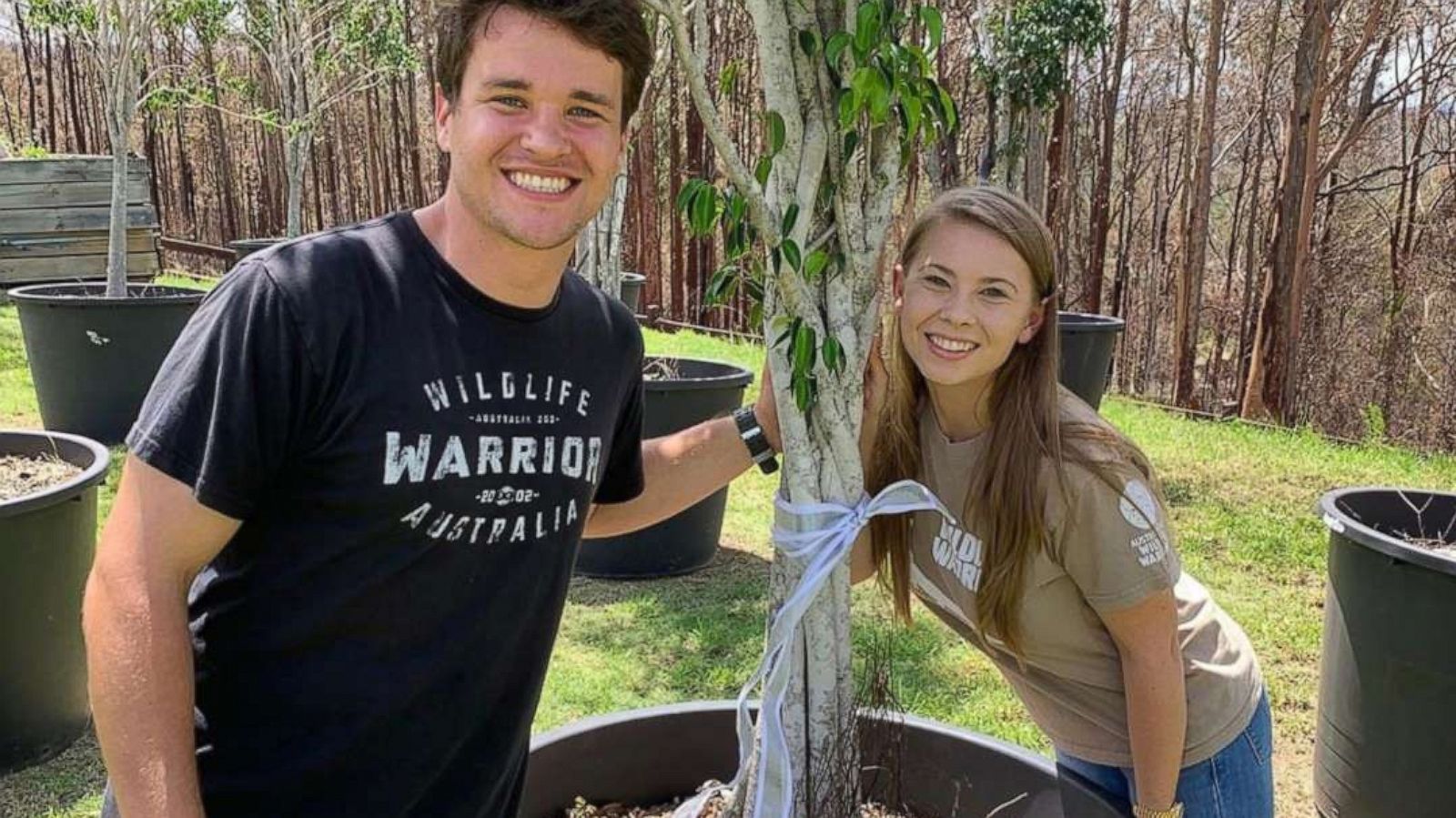 PHOTO: A photo posted to Bindi Irwin's Instagram account on April 7, 2020, shows her posing for a photo with Chandler Powell and a fig tree gifted to them by actor Russell Crowe.