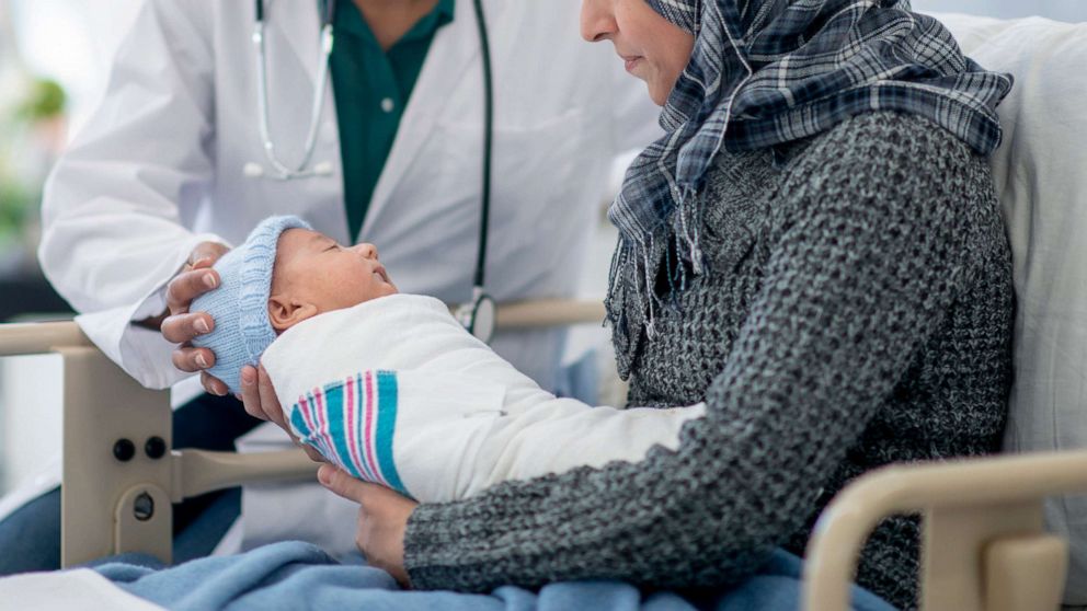 PHOTO: A mother holds her baby while seeing a doctor.