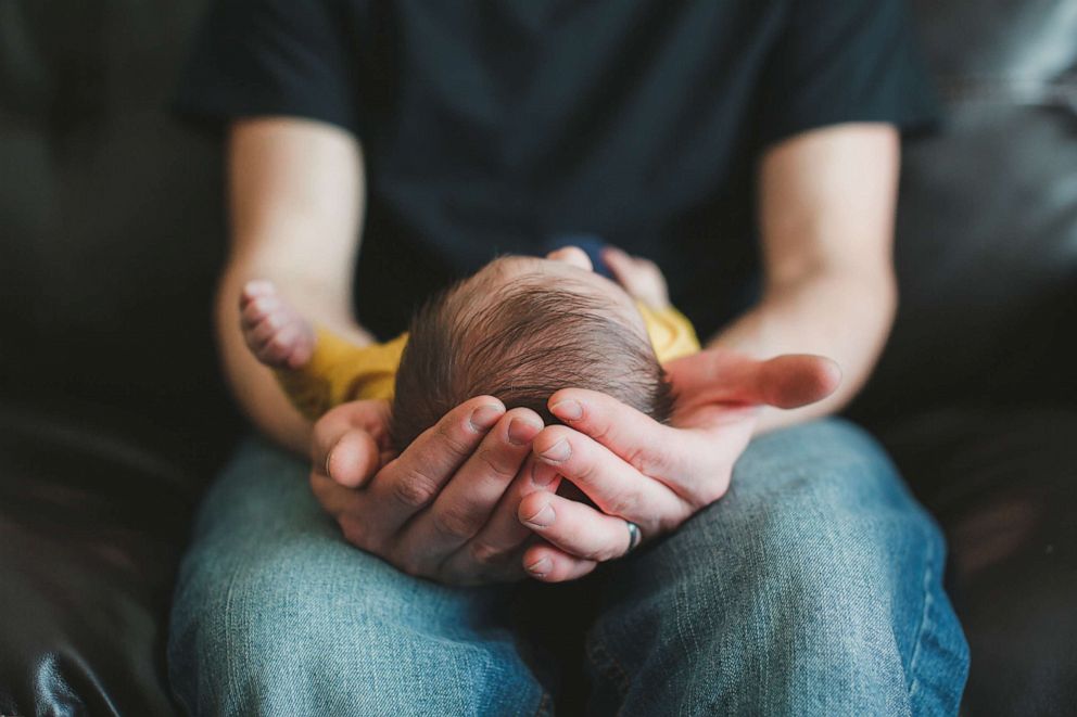 PHOTO: Newborn baby boy is cradled in his fathers hands.