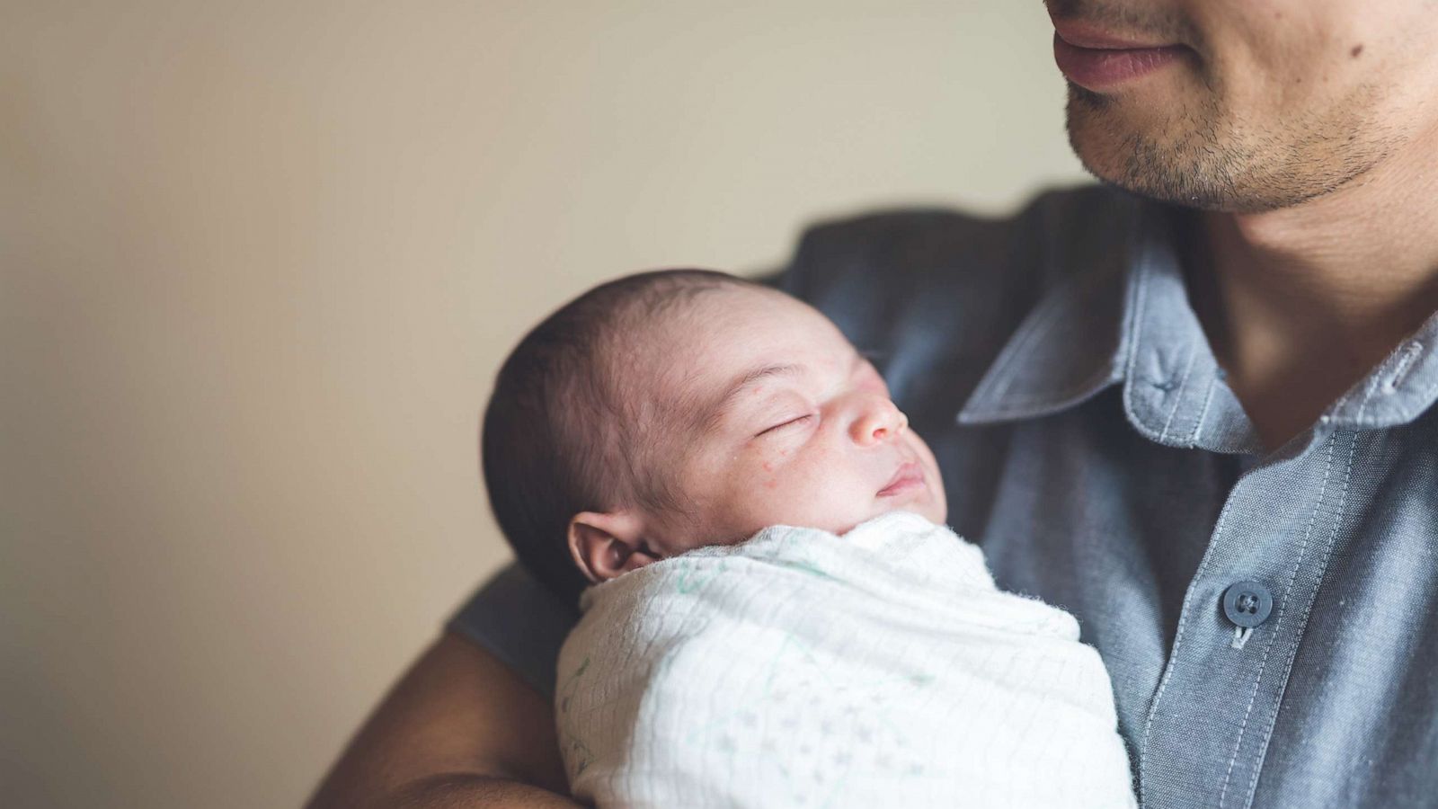 PHOTO: A dad cradles his newborn daughter in his arms.