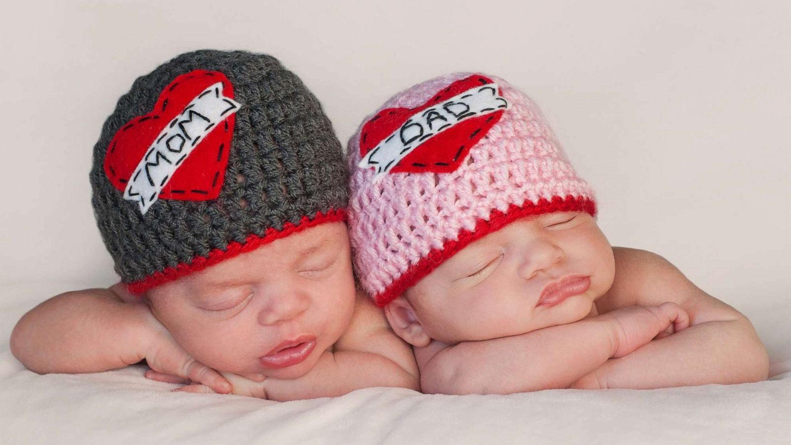 PHOTO: Sleeping baby boy and girl wear crocheted "Love Mom" and "Love Dad" beanies in this stock image.