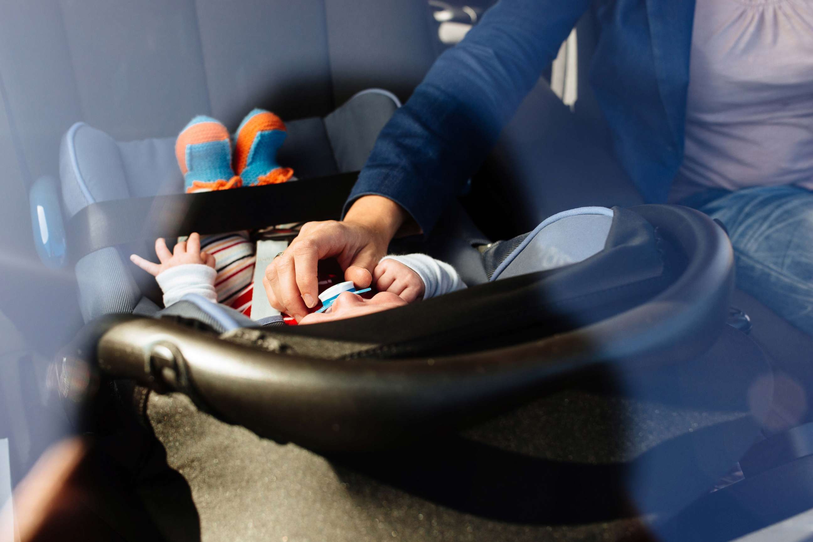 PHOTO: In this undated stock photo, a mother puts her baby in a rear facing car set.