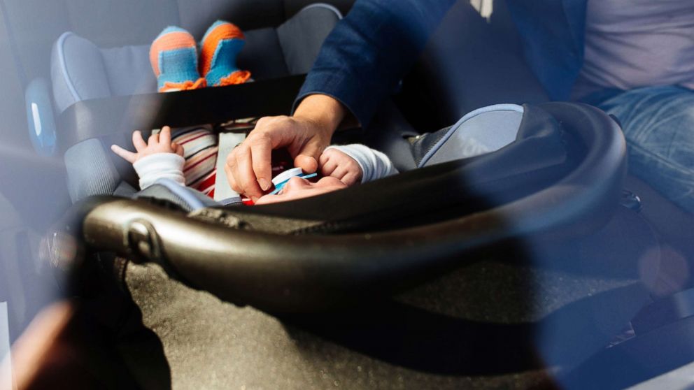 PHOTO: In this undated stock photo, a mother puts her baby in a rear facing car set.
