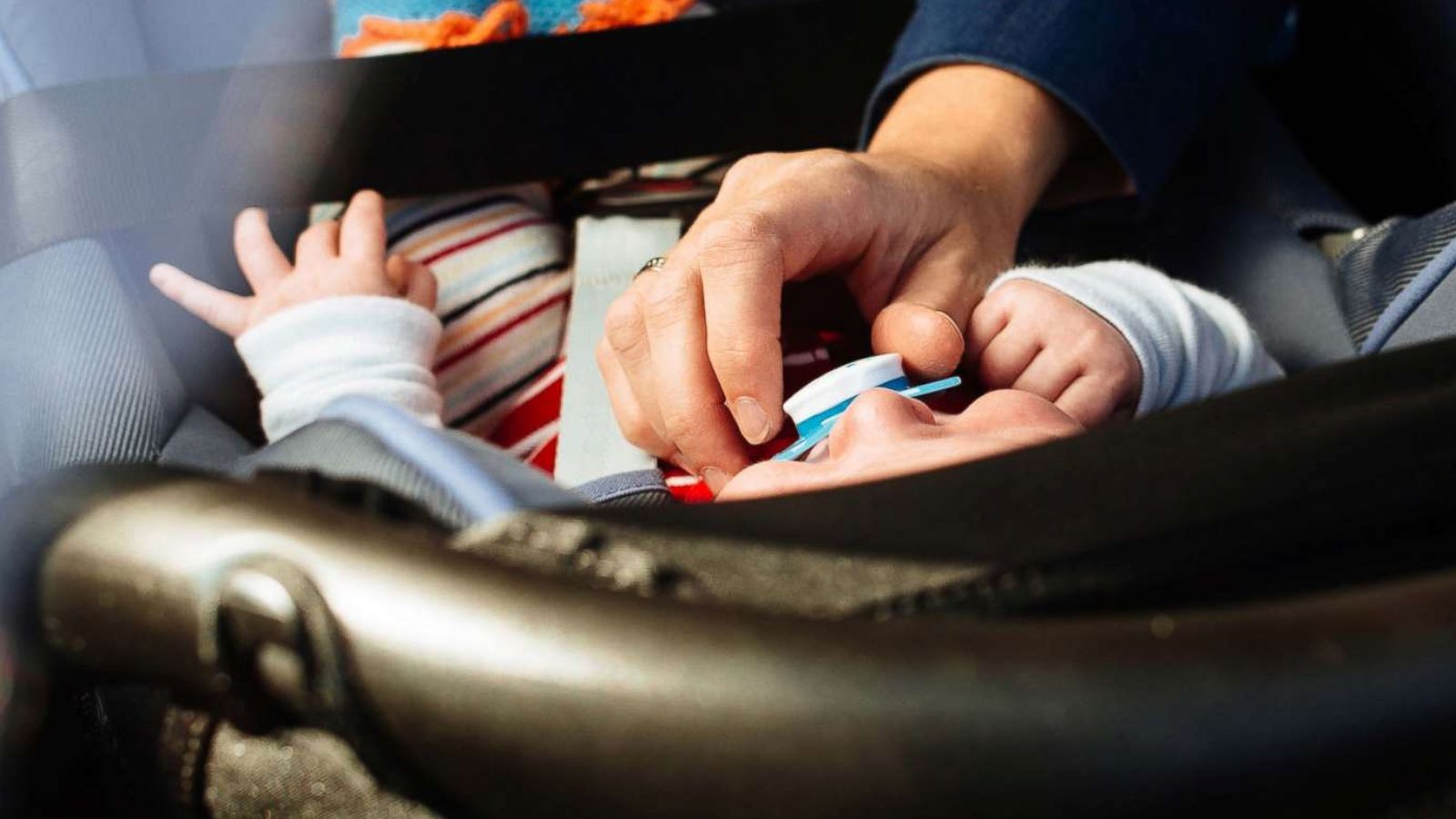 PHOTO: In this undated stock photo, a mother puts her baby in a rear facing car set.