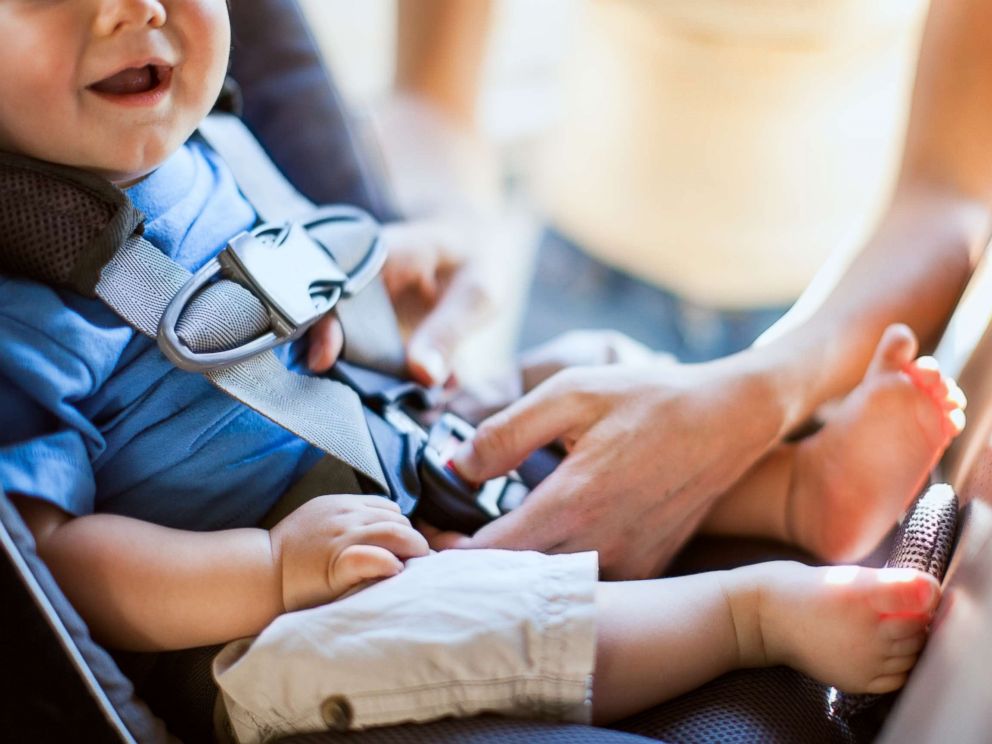 PHOTO: In this undated stock photo, a mom buckles her infant son safely into a rear facing car seat as they get ready to drive somewhere in their veh   icle.