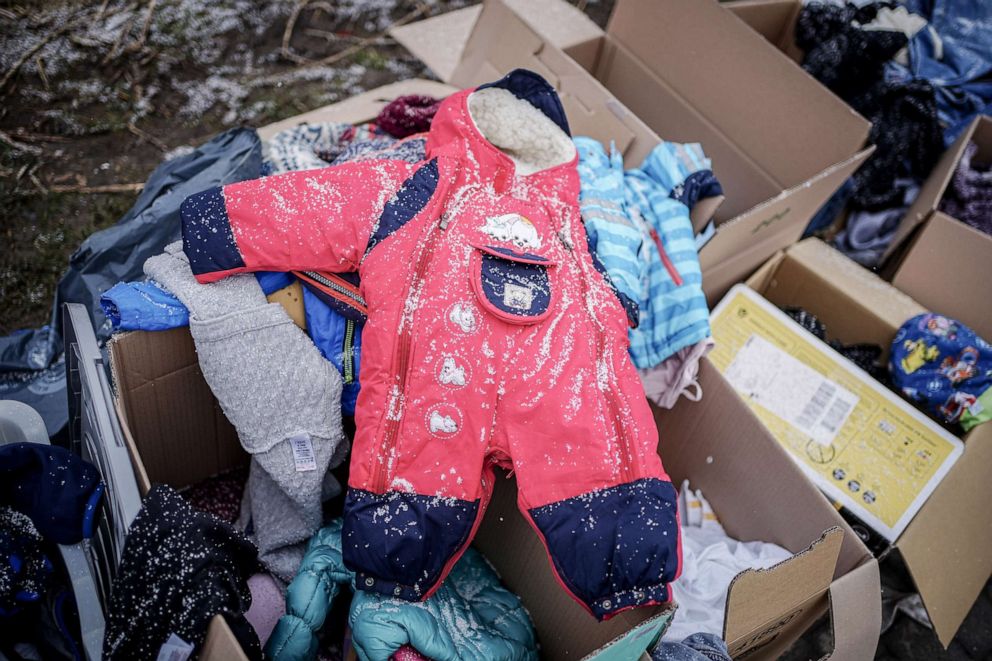 PHOTO: A snow-covered child's suit and other donated baby supplies are placed in boxes for the numerous people who arrive every day in Medyka, Poland, March 5, 2022, Poland.