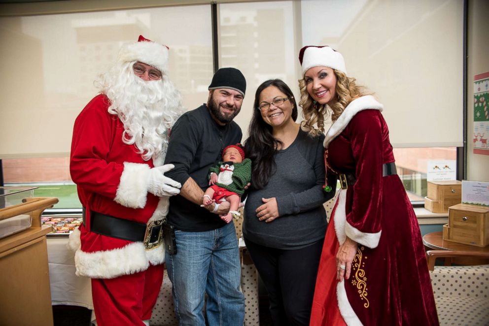 PHOTO: A family with their new baby in an ugly Christmas sweater onesie at UPMC Magee-Womens Hospital. 
