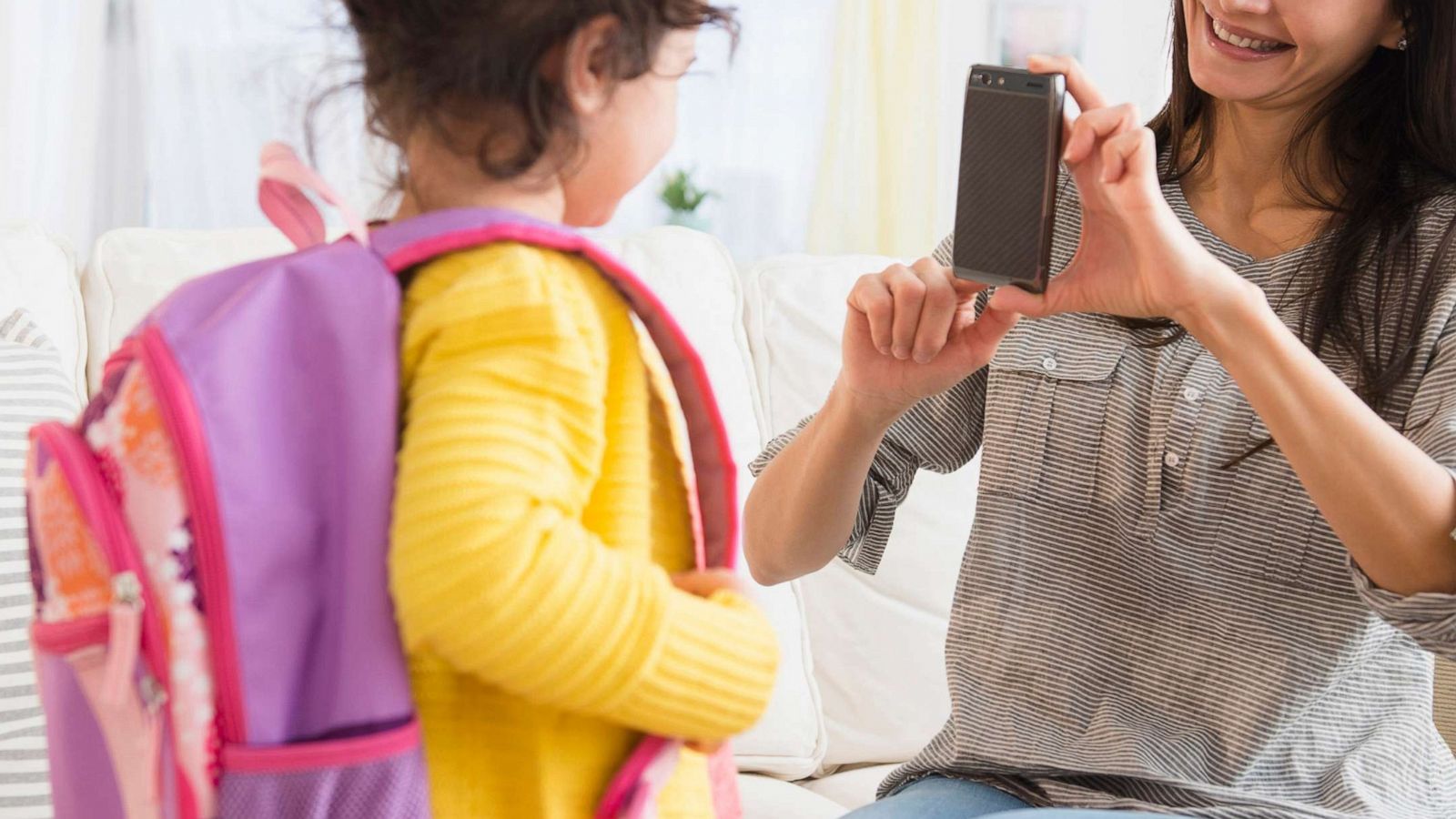 PHOTO: A mother takes a picture of her daughter while she gets ready for school in a stock image.