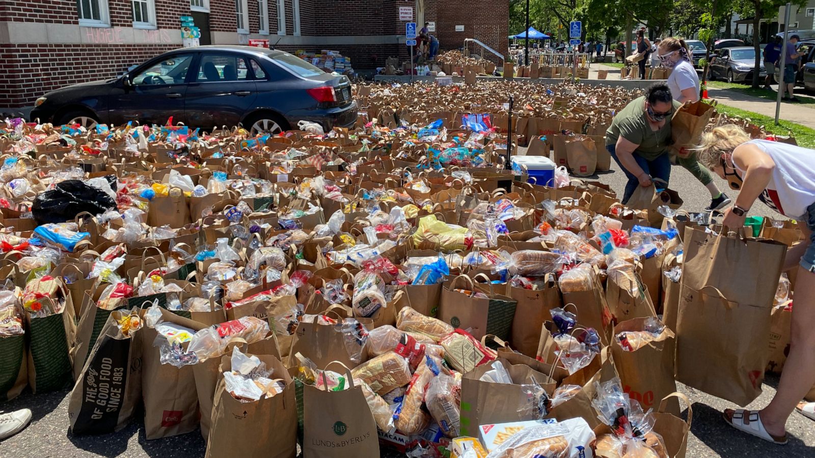 PHOTO: Donated food fills the parking lot and grass field at Sanford Middle School in Minneapolis.