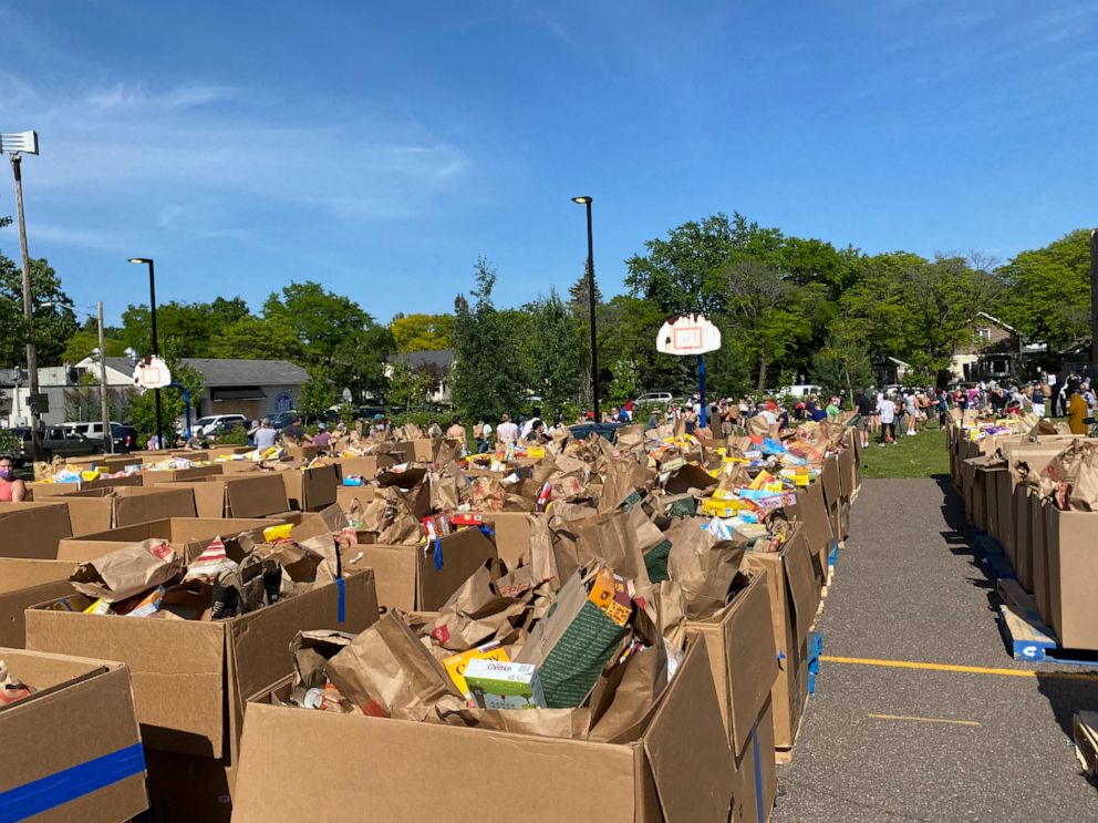 PHOTO: Donated food fills the parking lot and grass field at Sanford Middle School in Minneapolis.