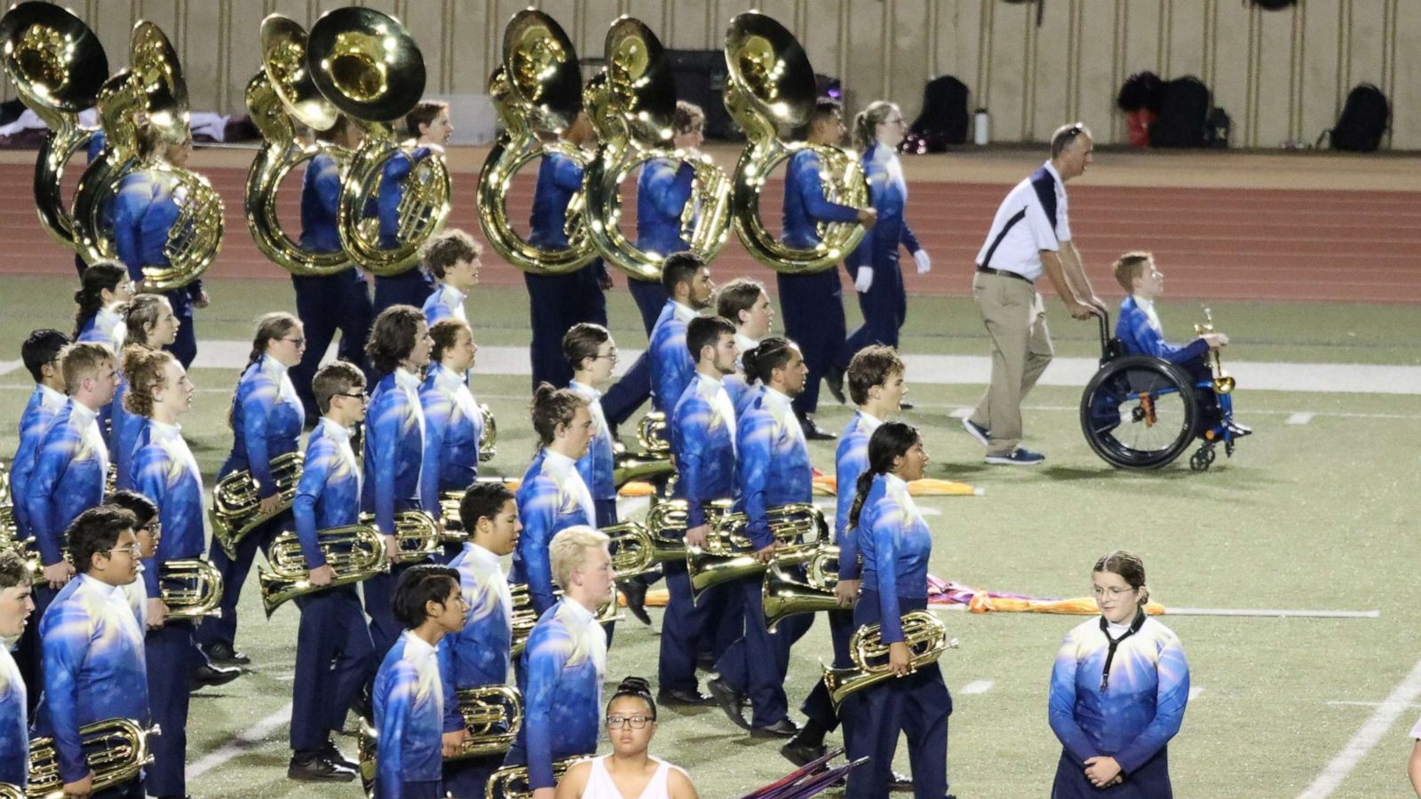 PHOTO: Southmoore High School band director Adam Mewhorter pushes student Casey, who uses a wheelchair, on the field when he performs with the school's marching band.