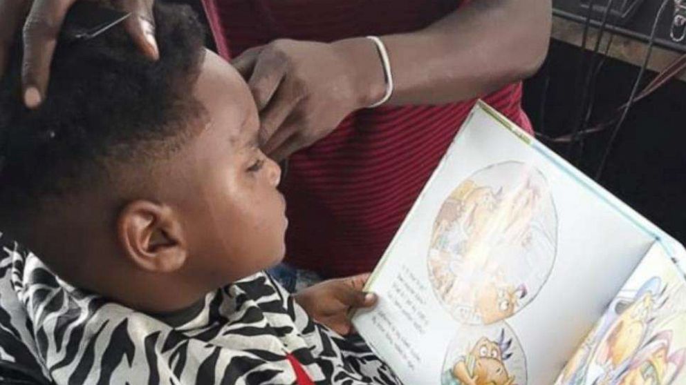 PHOTO: Jermaine Scott's "Barbershop Books Day" offers discounts to kids who read during their haircuts.