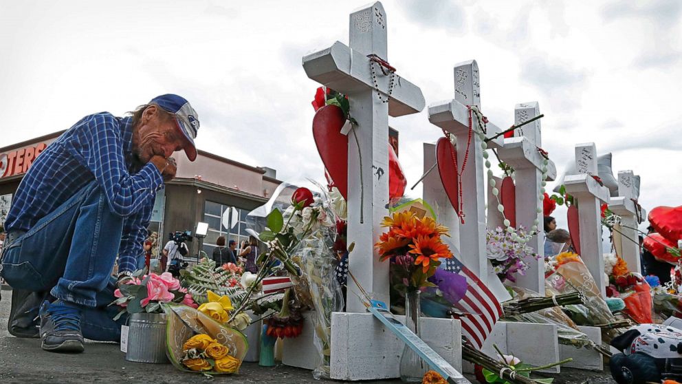 PHOTO: Antonio Basco kneels in front of the cross for his partner Margie Reckard at the make shift memorial honoring the victims of the mass shooting in El Paso, Texas, Aug. 6 2019.