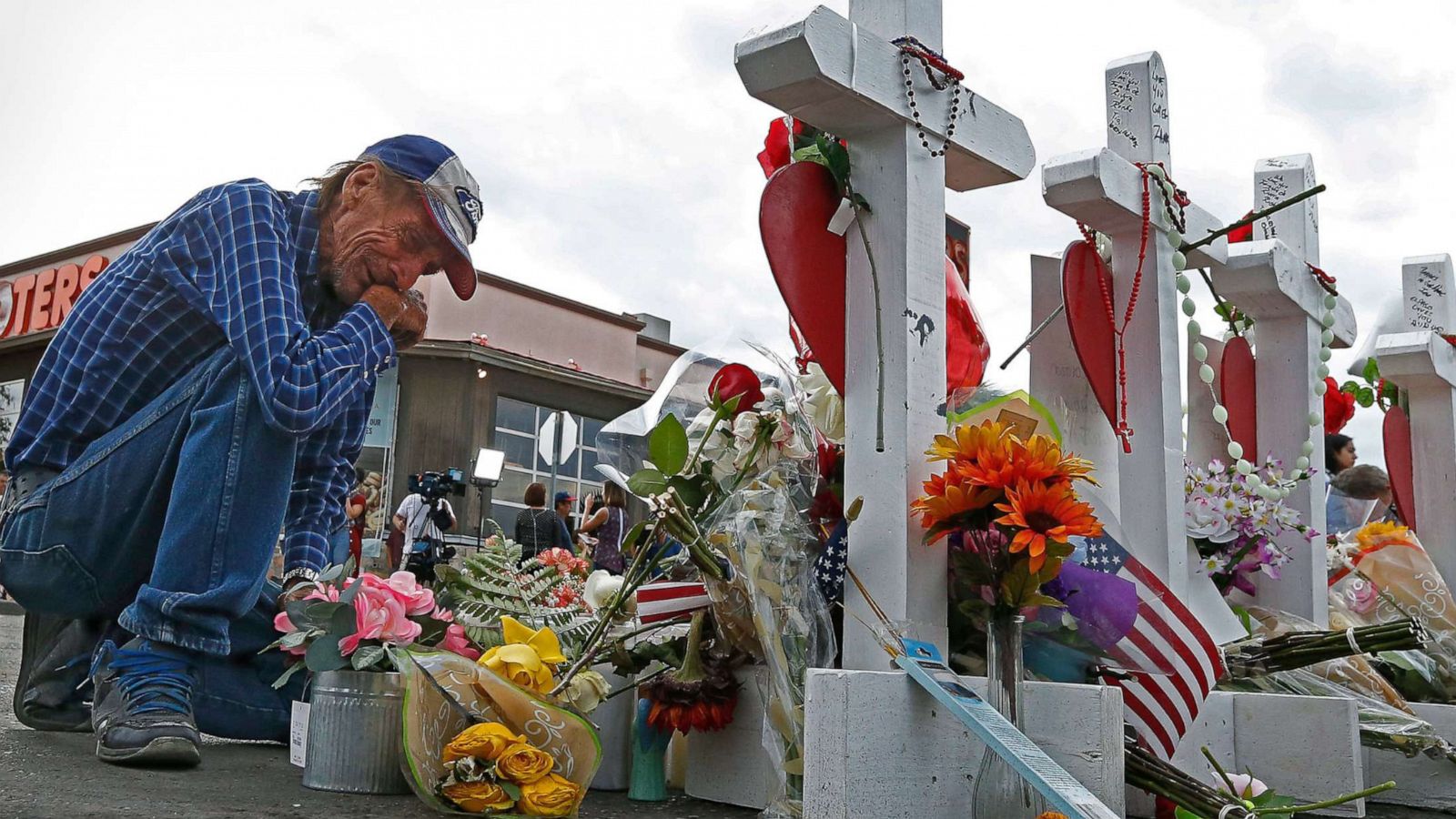 PHOTO: Antonio Basco kneels in front of the cross for his partner Margie Reckard at the make shift memorial honoring the victims of the mass shooting in El Paso, Texas, Aug. 6 2019.