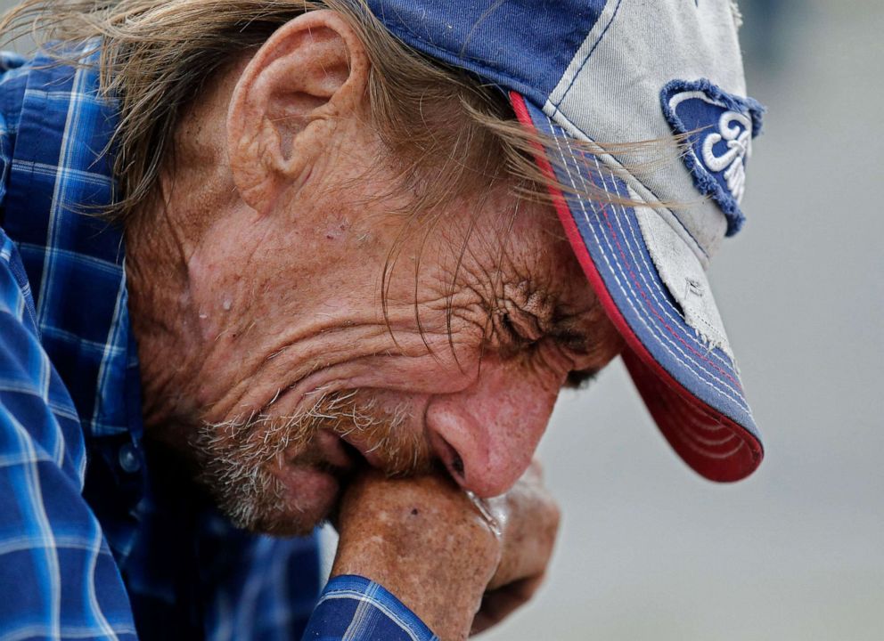 PHOTO: Antonio Basco cries while kneeling in front of the cross for his partner Margie Reckard at the make shift memorial for the mass shooting at a Walmart in El Paso, Texas, Aug. 6, 2019.