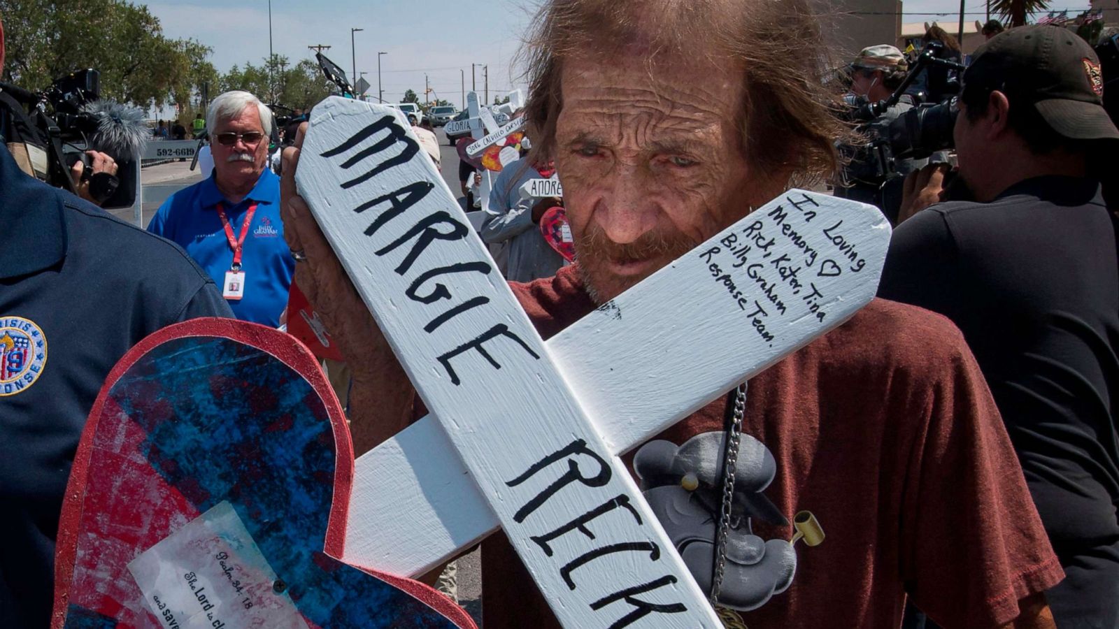 PHOTO: Antonio Basco holds the cross of his common-law wife, Margie Reckard, who died in the Walmart shooting as he walks to a makeshift memorial in El Paso, Texas, Aug. 5, 2019.