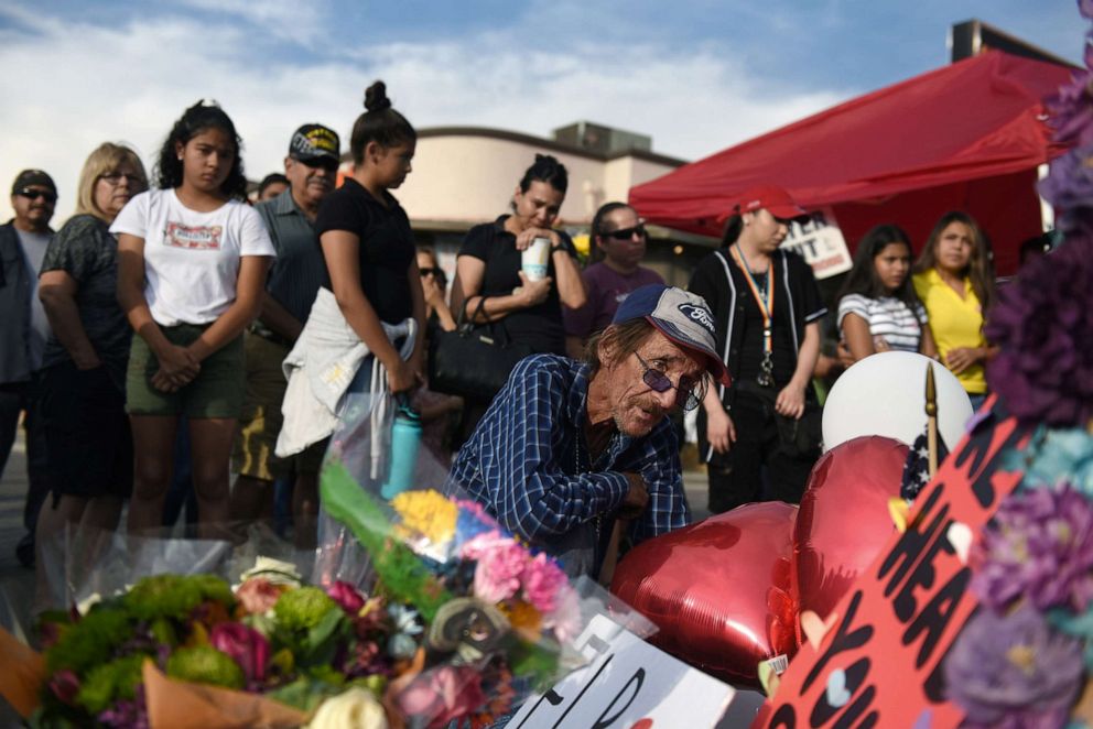 PHOTO: Antonio Basco looks at the cross bearing the name of his partner Margie Reckard, who died during the mass shooting at a Walmart store in El Paso, Texas, Aug. 7, 2019.