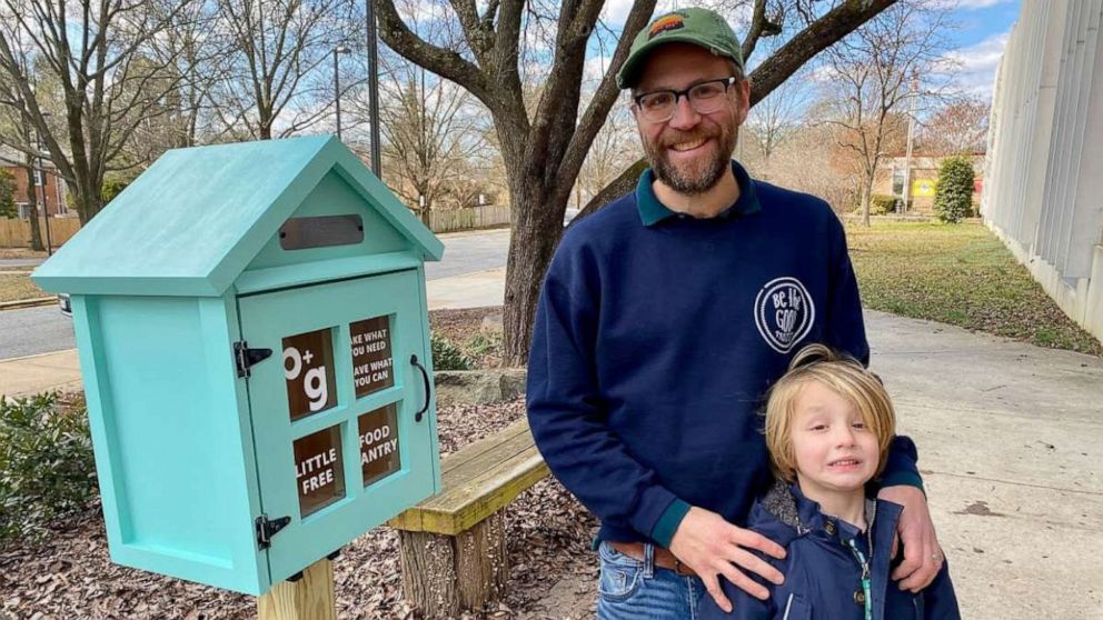 PHOTO: Sterling Marchand and his son pose in front of a little free food pantry.