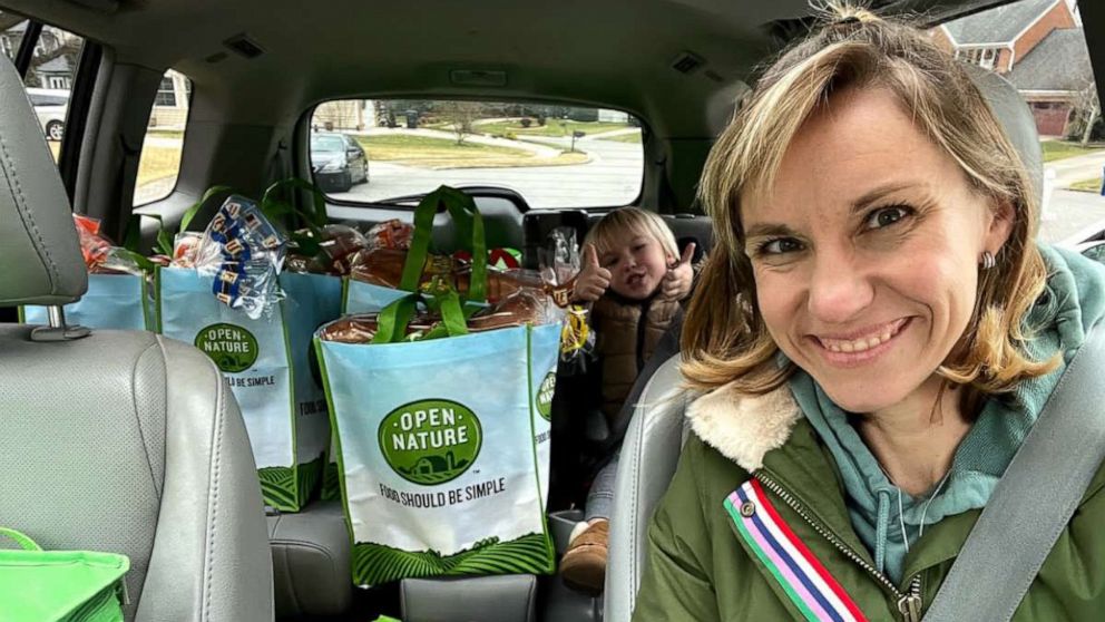 PHOTO: Amber Marchand and her son pose in the car with food they have collected for charity.