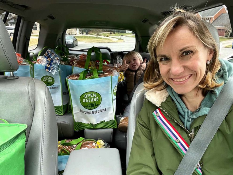 PHOTO: Amber Marchand and her son pose in the car with food they have collected for charity.