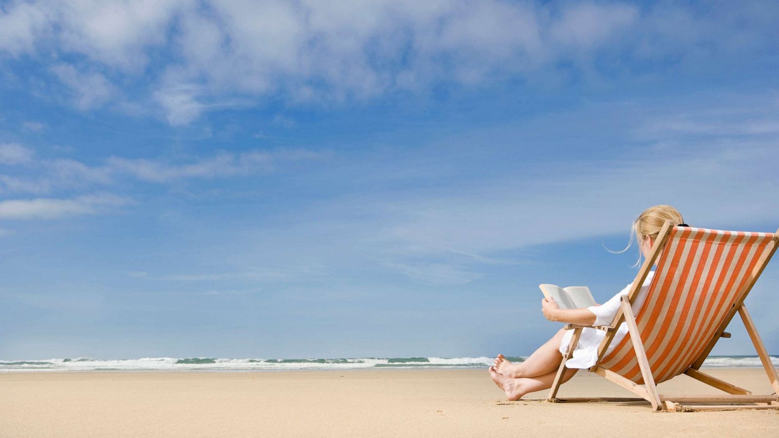 PHOTO: A woman reads a book on the beach.