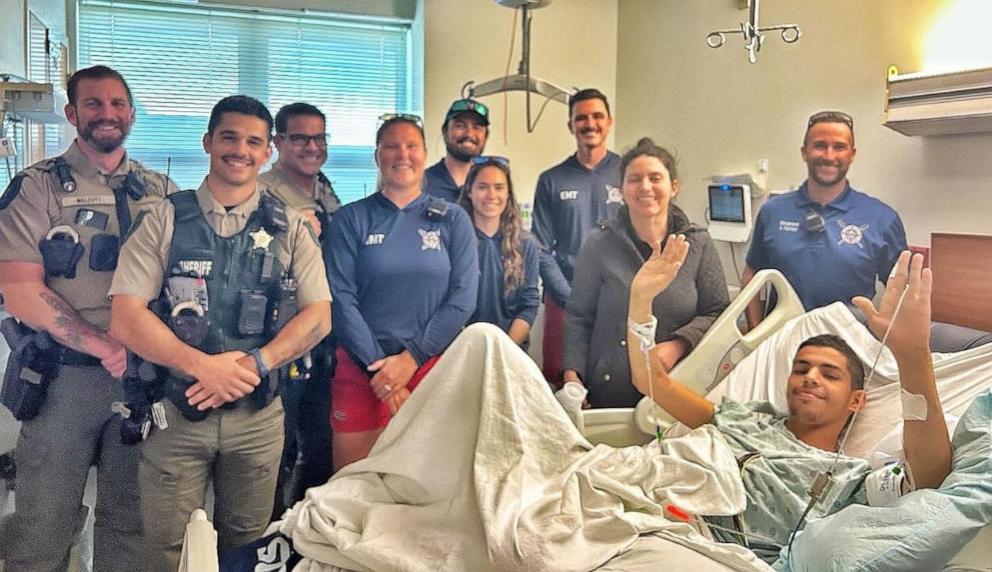 PHOTO: First responders reunited with Felipe Desouza after they rescued him from a rip current, March 30, 2024, off the coast of New Smyrna Beach, Fla.