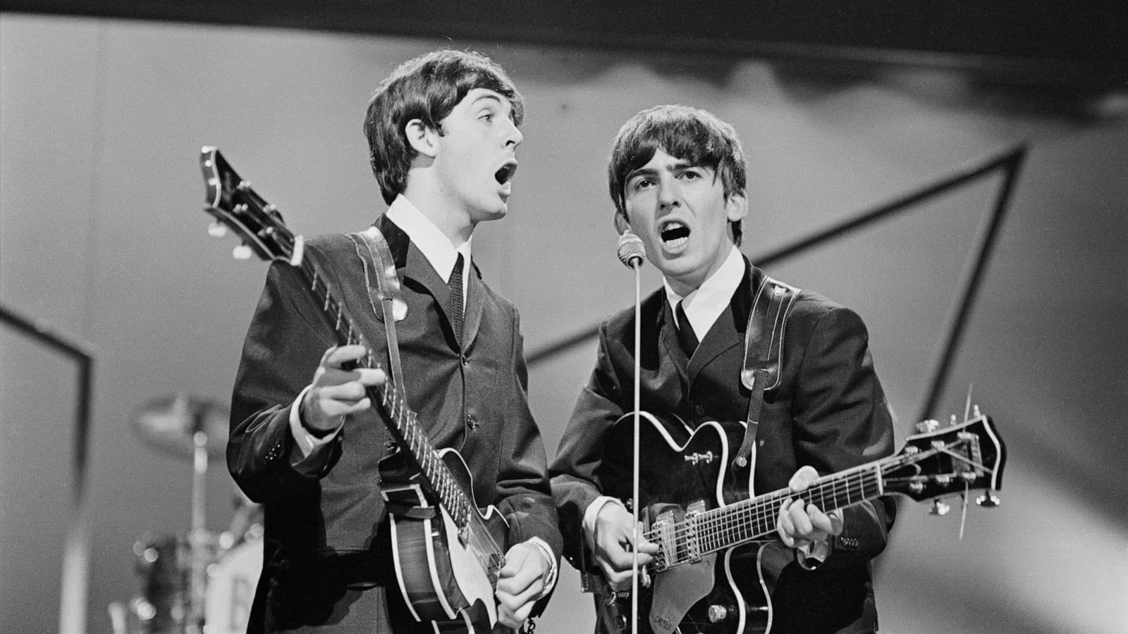 PHOTO: Paul McCartney and George Harrison of the Beatles perform on stage at the London Palladium, U.K., Oct. 13, 1963.