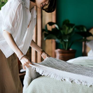 PHOTO: Stock photo of a woman making a bed.