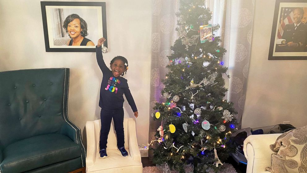 PHOTO: Soleil Irving points to a photo of her late mom, Shalon Irving, in her family's 2021 Christmas card photo.