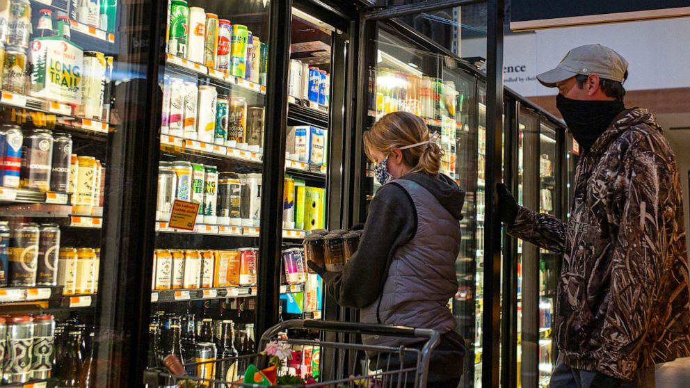 PHOTO: In this May 9, 2020 file photo shoppers at the City Market select beer from a supermarket cooler in South Burlington, Vt.