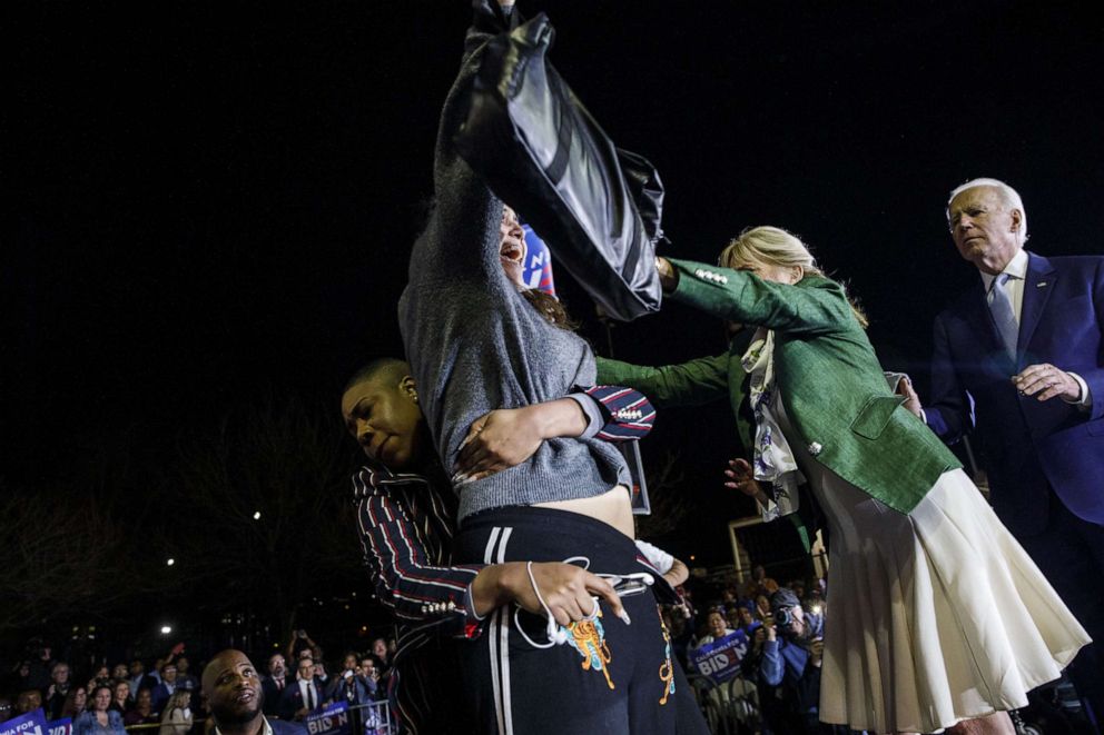 PHOTO: Former Vice President Joe Biden, right, watches as his wife Jill Biden, second right, and his senior adviser Symone Sanders block a protester during a primary night rally in the Baldwin Hills neighborhood of Los Angeles, March 3, 2020.