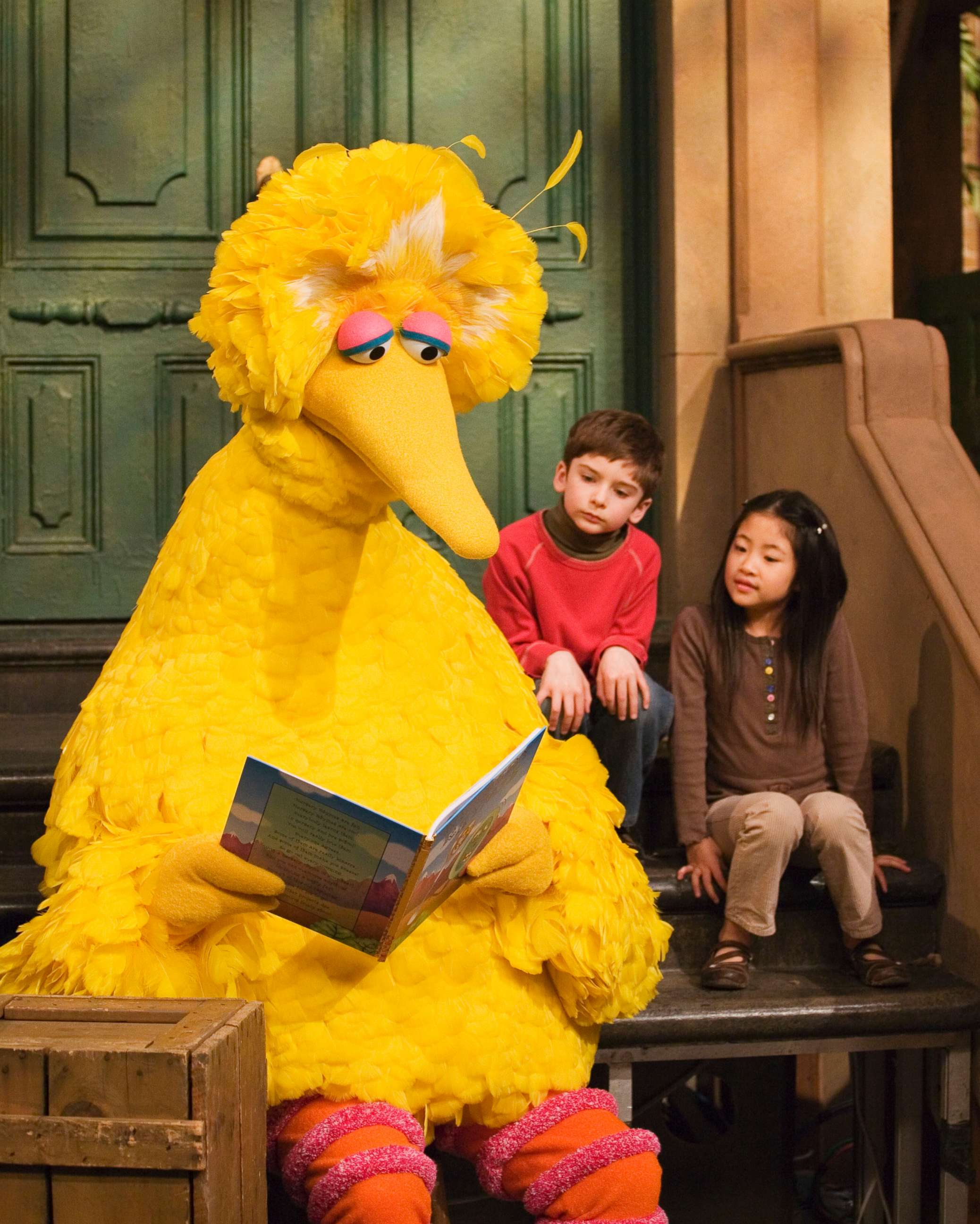 PHOTO: Big Bird reads to Connor Scott and Tiffany Jiao during a taping of Sesame Street in New York, April 10, 2008. Caroll Spinney, the puppeteer who has played Big Bird on "Sesame Street" is retiring after nearly 50 years on the show. 