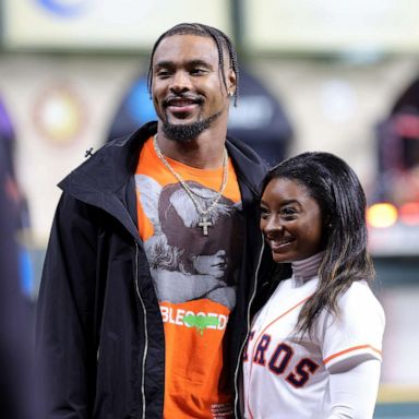 PHOTO: Simone Biles and Jonathan Owens pose on the field prior to Game One of the 2022 World Series between the Philadelphia Phillies and the Houston Astros at Minute Maid Park, Oct. 28, 2022 in Houston, Texas.