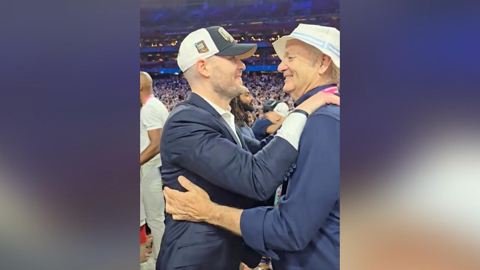 PHOTO: Luke Murray embraces dad, Bill Murray, after coaching UConn's NCAA tournament win.