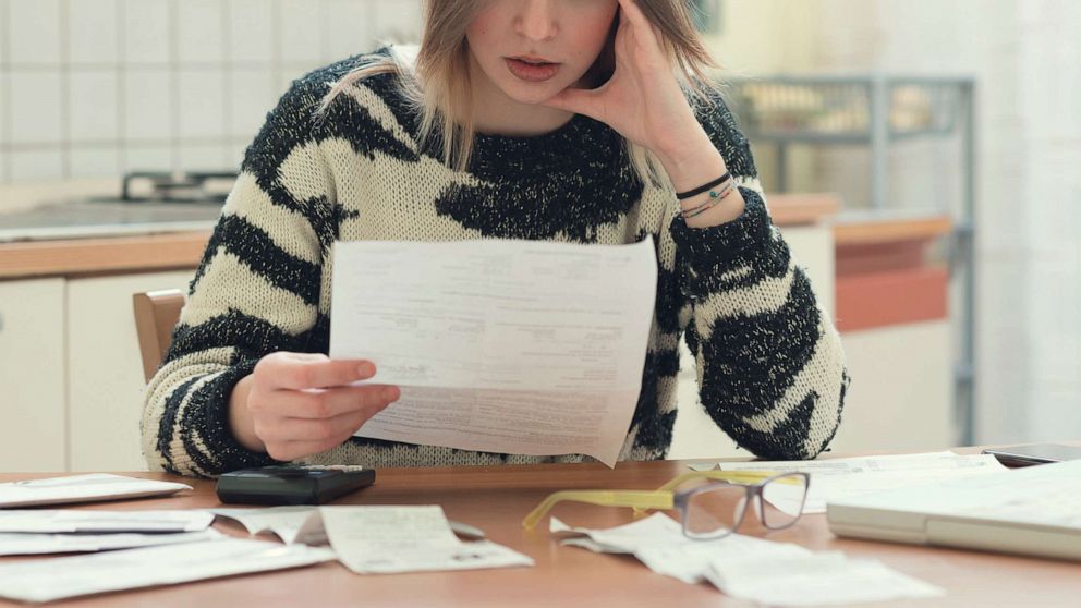 PHOTO: A woman pays bills in an undated stock photo.