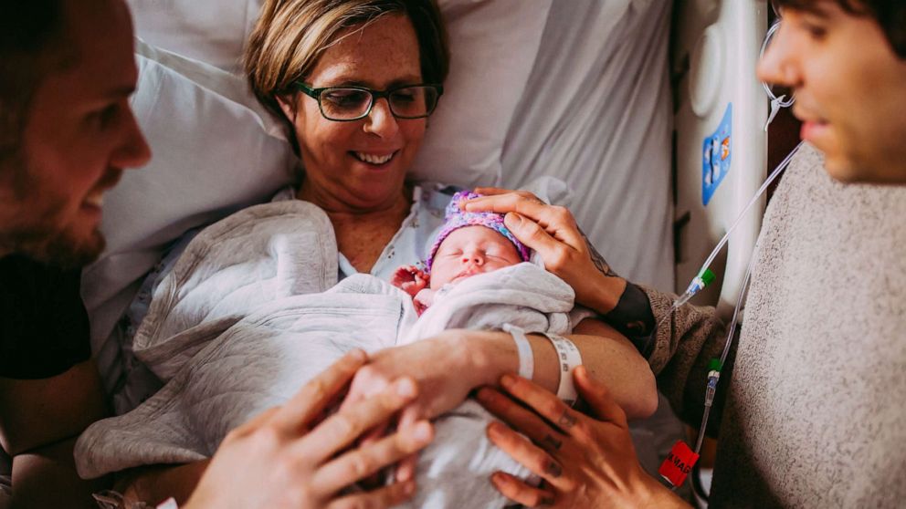 PHOTO: Cecile Eledge holds her granddaughter, Uma, alongside her son and son-in-law.