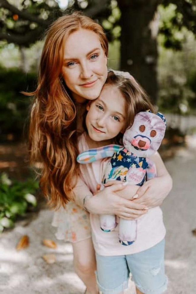 PHOTO: Chloe Sexton hugs her younger sister, Charlotte, who is holding a memory bear plush named "Jenny Wren," after their late mother.