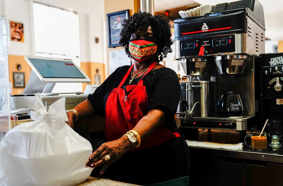 PHOTO: In this Nov. 6, 2020, file photo, 'Miss Val' Rimmer poses for a portrait while working behind the counter at Coffee Makes You Black, a Black-owned coffee shop in Milwaukee, Wis.