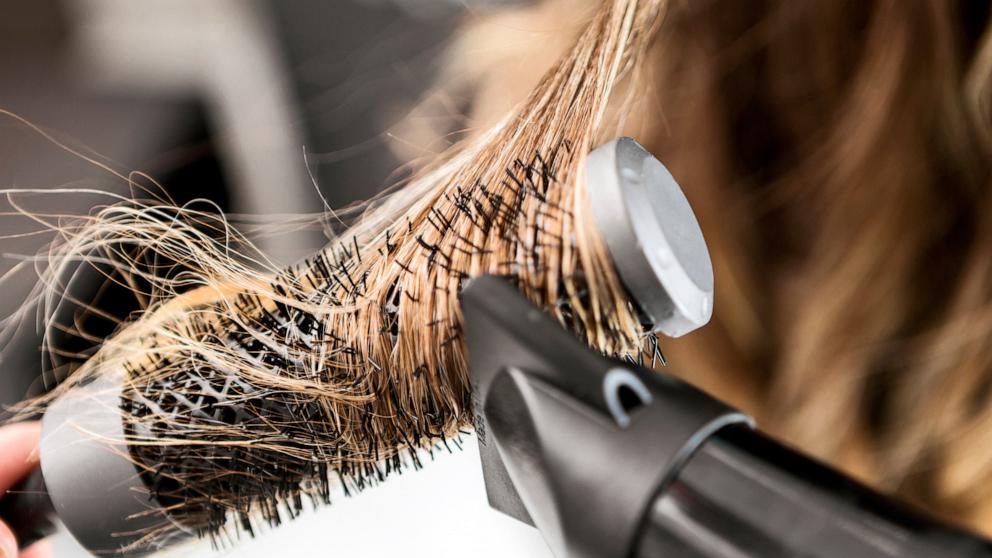PHOTO: Stock photo of a person blowdrying their hair.