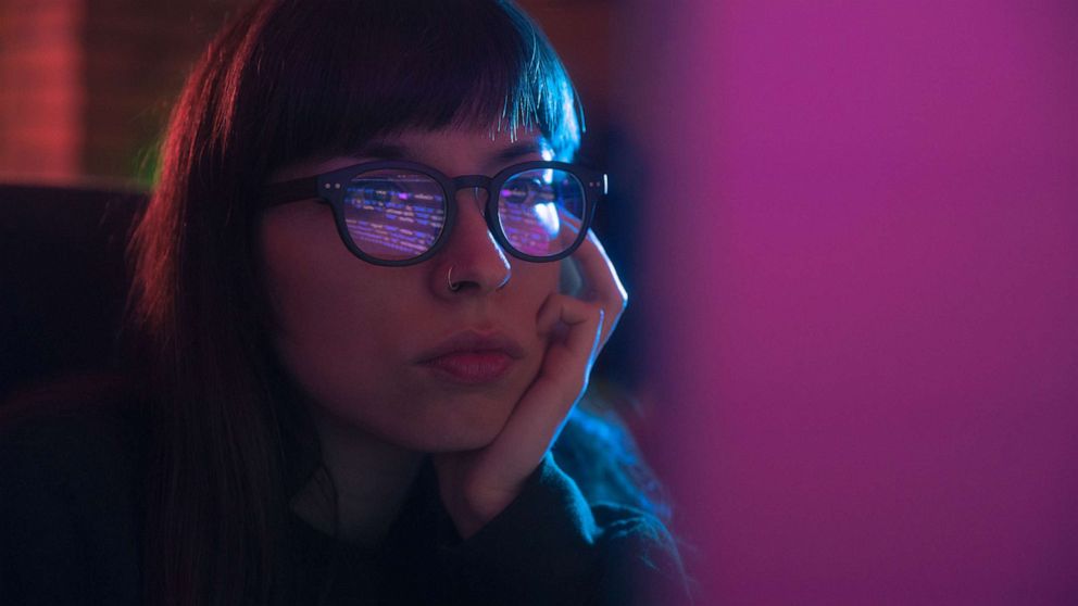 PHOTO: A woman is seen using computer with blue glasses in this stock image.