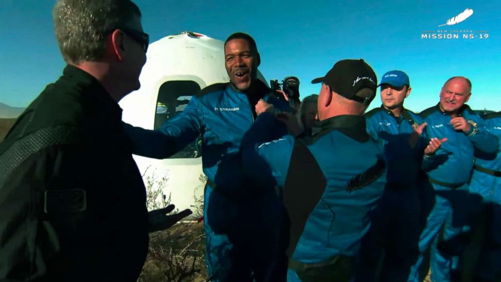 PHOTO: Jeff Bezos attaches a pin to Michael Strahan's collar after Blue Origin's New Shepard landed successfully, Dec. 11, 2021, in West Texas.