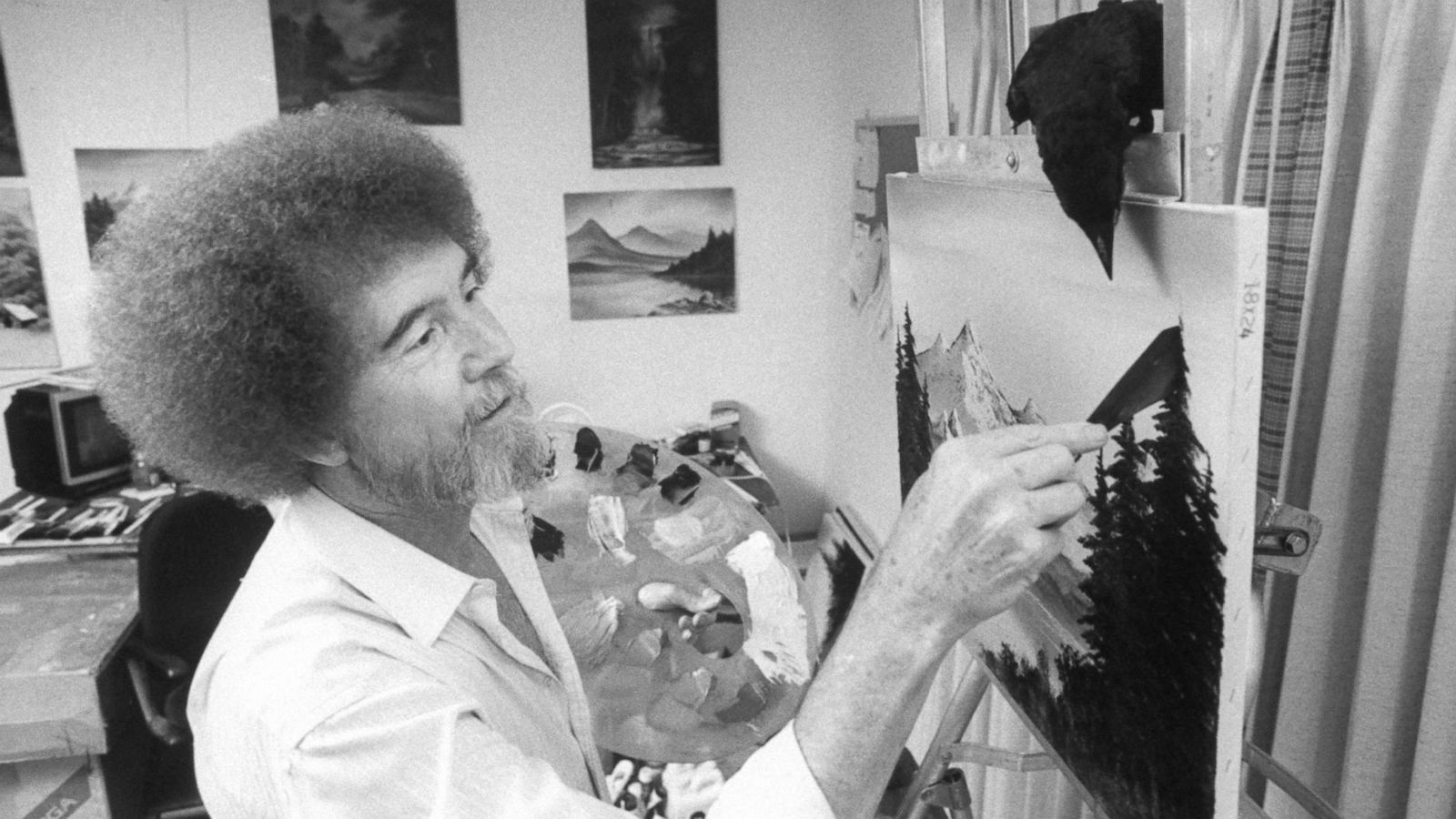 PHOTO: TV painting instructor/artist Bob Ross paints one of his landscapes as his pet crow watches closely from its perch on top of easel in studio at home on July 16, 1991.