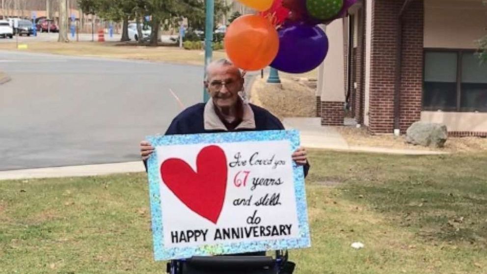 PHOTO: Man holds sign for his wife outside of nursing home for their 67th anniversary after they ban visitors due to coronavirus