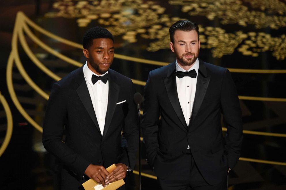 PHOTO: Chadwick Boseman and Chris Evans speak onstage during the 88th annual Academy Awards at the Dolby Theatre, Feb. 28, 2016, in Hollywood, Calif.
