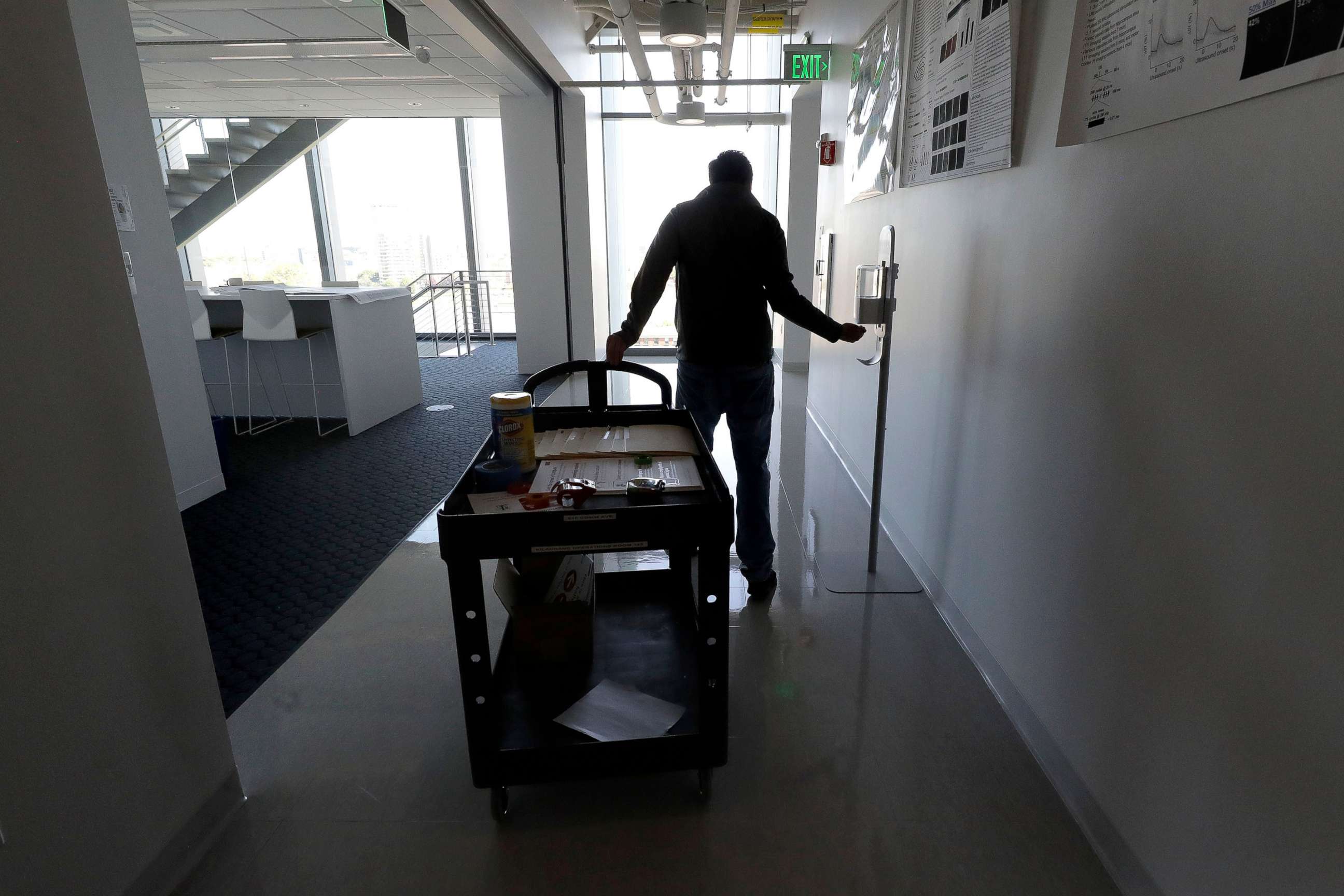 PHOTO: Kevin Gonzales reaches for hand sanitizer as he enters a room to install safe distancing measures at Boston University campus, in Boston, May 21, 2020.