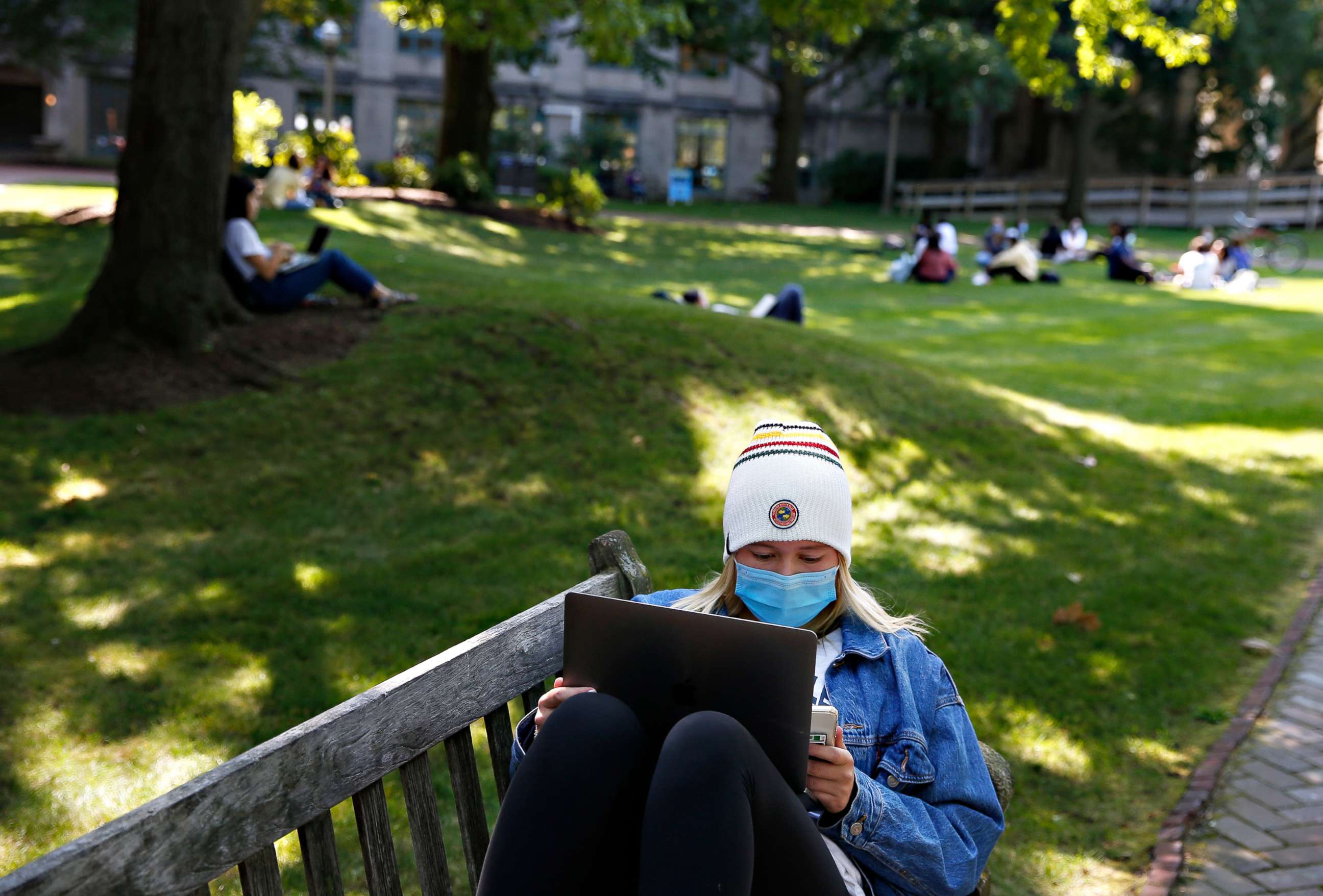 PHOTO:A student wears a mask as she works on her laptop outside on the BU Beach at Boston University in Boston on Sept. 23, 2020.