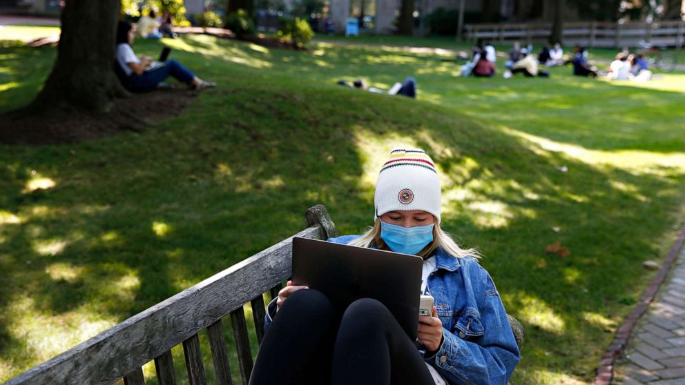 PHOTO:A student wears a mask as she works on her laptop outside on the BU Beach at Boston University in Boston on Sept. 23, 2020.