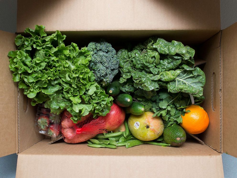 PHOTO: Cardboard box full of fresh organic fruits and vegetables including lettuce.