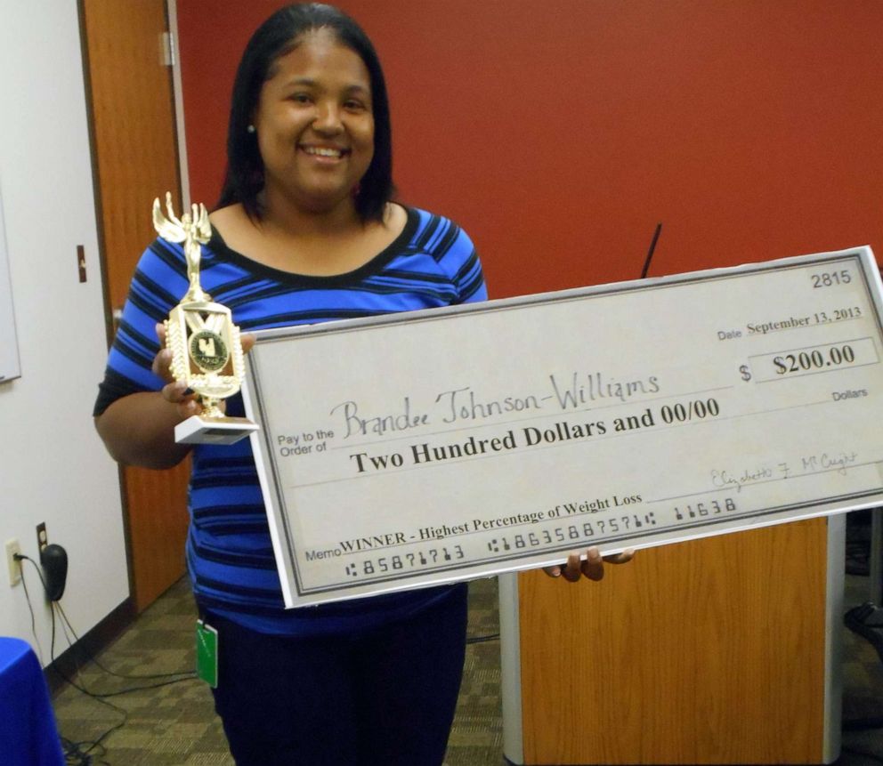 PHOTO: Brandee Johnson, 40, of Chattanooga, Tenn., holds a trophy and a check for winning an office weight loss challenge in 2013.