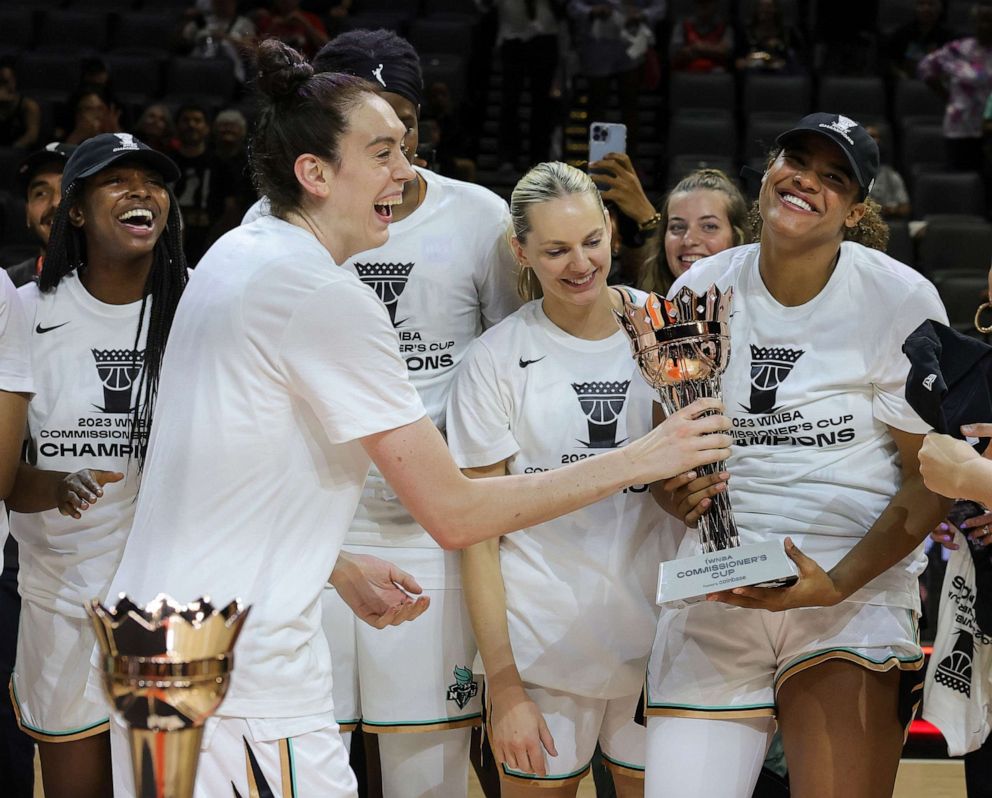 PHOTO: Breanna Stewart of the New York Liberty hands the championship trophy to teammate Nyara Sabally after the team's victory in the 2023 Commissioner's Cup Championship game at Michelob ULTRA Arena, Aug. 15, 2023, in Las Vegas.